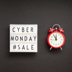 Creative Top view flat lay promotion composition Cyber Monday sale text on lightbox alarm clock
